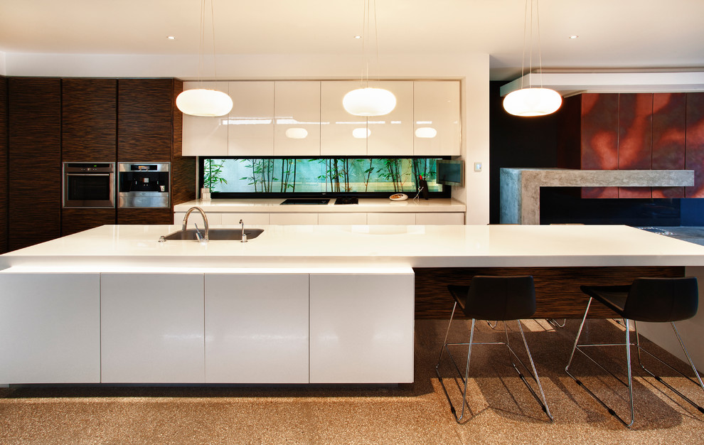Expansive contemporary open plan kitchen in Melbourne with a double-bowl sink, dark wood cabinets, solid surface benchtops, window splashback, stainless steel appliances, concrete floors and with island.