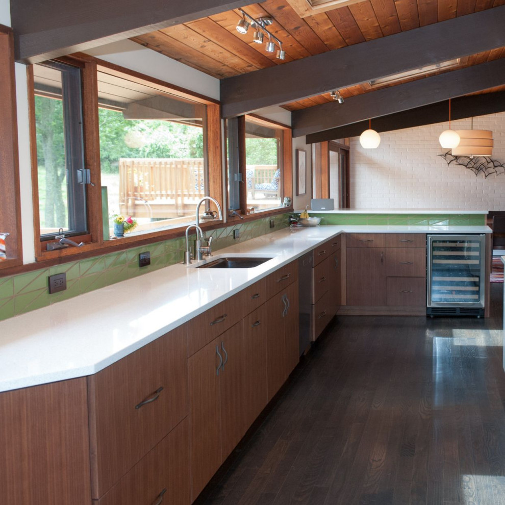 Midcentury eat-in kitchen in Philadelphia with an undermount sink, flat-panel cabinets, quartz benchtops, green splashback, stainless steel appliances, a peninsula, brown floor and white benchtop.