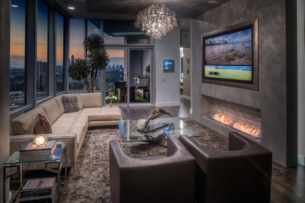 Photo of a large modern open concept living room in Houston with grey walls, dark hardwood floors, a standard fireplace, a tile fireplace surround and a built-in media wall.