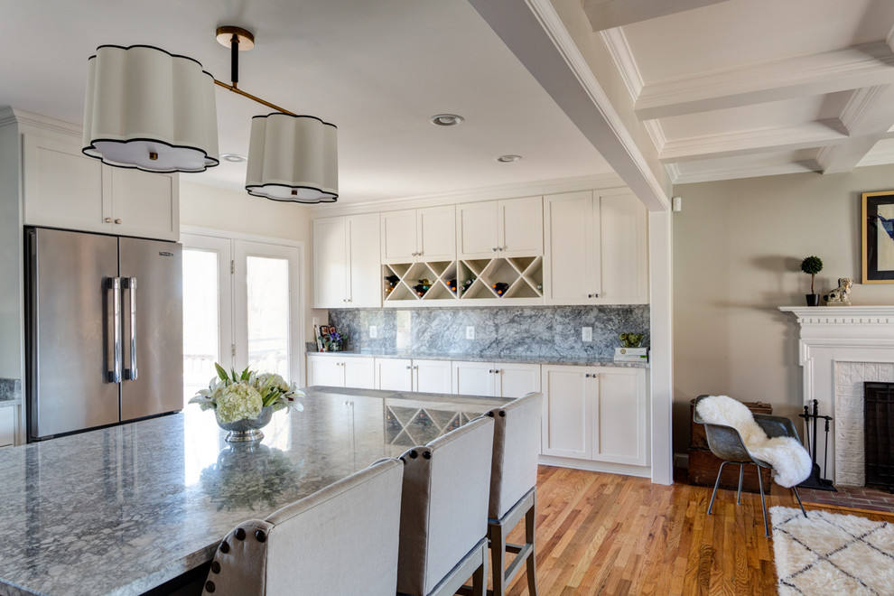 Kitchen - transitional light wood floor kitchen idea with an island, a single-bowl sink, shaker cabinets, white cabinets, quartzite countertops, gray backsplash, stone slab backsplash and stainless steel appliances