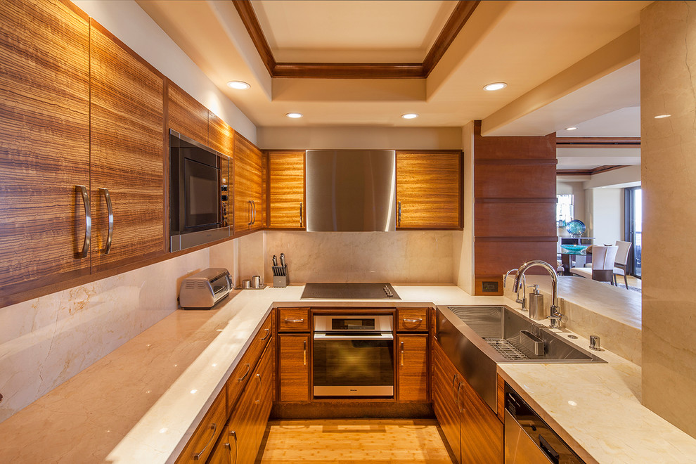 Photo of a small modern galley separate kitchen in San Diego with a farmhouse sink, light wood cabinets, marble benchtops, beige splashback, stainless steel appliances, bamboo floors, no island, flat-panel cabinets and marble splashback.