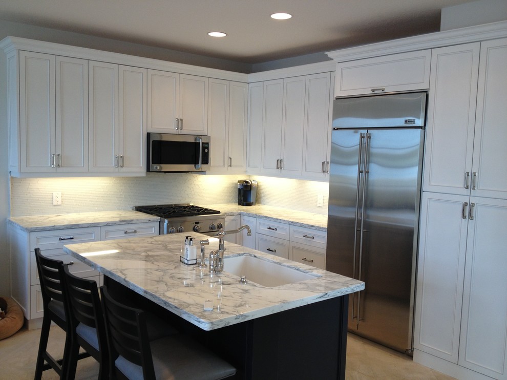 Inspiration for a mid-sized transitional u-shaped travertine floor and beige floor open concept kitchen remodel in Miami with an undermount sink, shaker cabinets, white cabinets, marble countertops, multicolored backsplash, glass tile backsplash, stainless steel appliances and an island