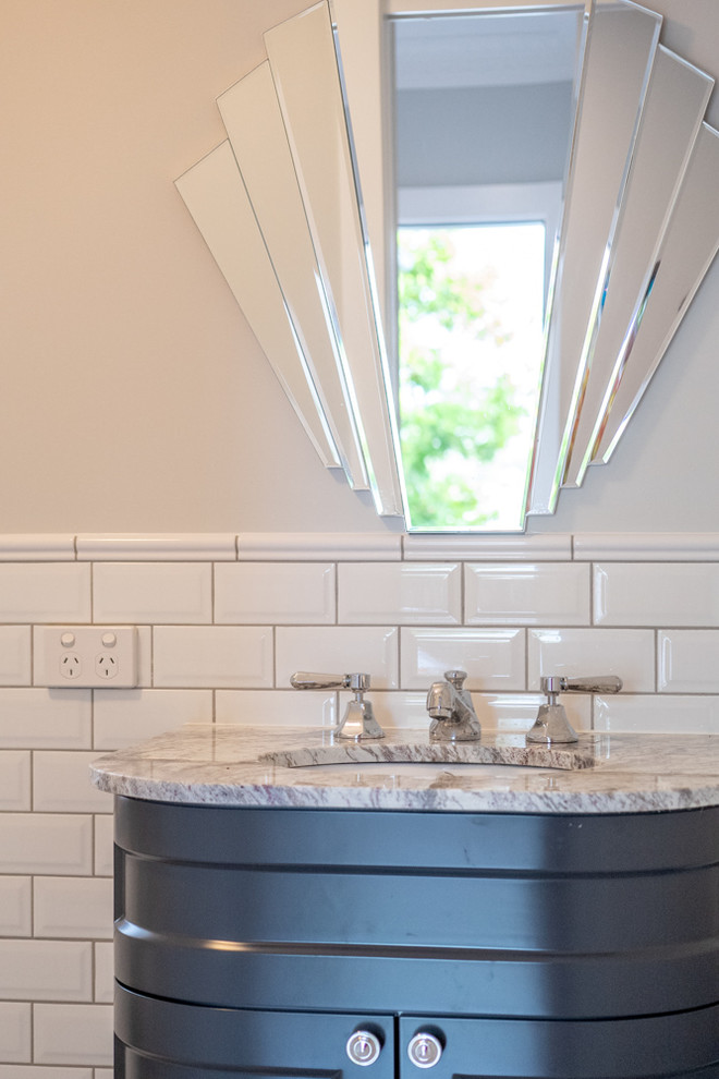 Traditional powder room in Brisbane with a one-piece toilet, white tile, subway tile, grey walls, ceramic floors, an undermount sink, marble benchtops, beige floor and grey benchtops.