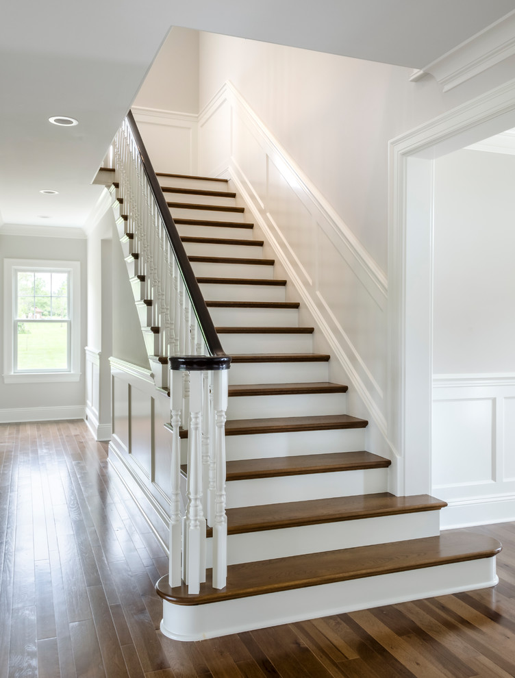 Mid-sized traditional wood u-shaped staircase in Cleveland with painted wood risers and wood railing.