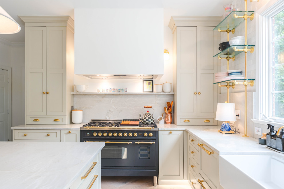 Inspiration for a large u-shaped eat-in kitchen in DC Metro with a farmhouse sink, shaker cabinets, green cabinets, quartzite benchtops, white splashback, porcelain splashback, black appliances, light hardwood floors, with island, grey floor and white benchtop.