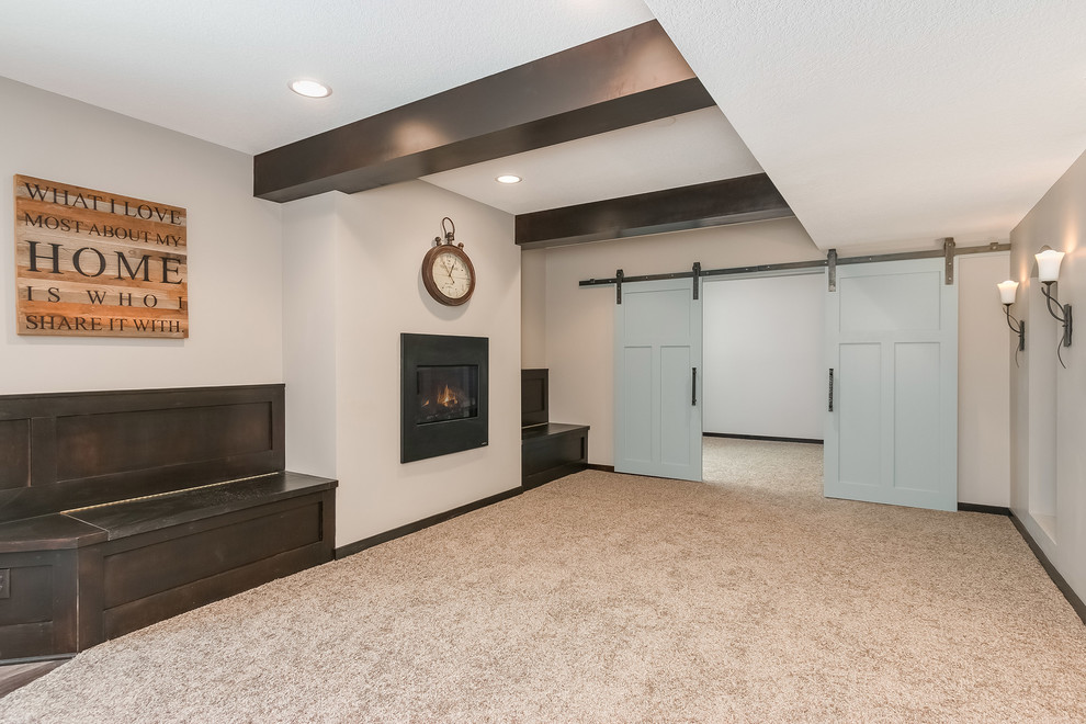 This is an example of a large transitional walk-out basement in Minneapolis with carpet, grey walls, a ribbon fireplace, a metal fireplace surround and beige floor.