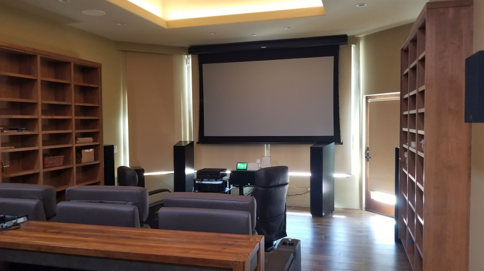 Design ideas for a mid-sized contemporary enclosed home theatre in Phoenix with green walls, medium hardwood floors, a projector screen and brown floor.