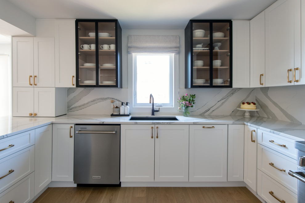 Eat-in kitchen - mid-sized transitional u-shaped light wood floor and brown floor eat-in kitchen idea in Ottawa with an undermount sink, shaker cabinets, white cabinets, quartz countertops, white backsplash, quartz backsplash, stainless steel appliances, a peninsula and white countertops