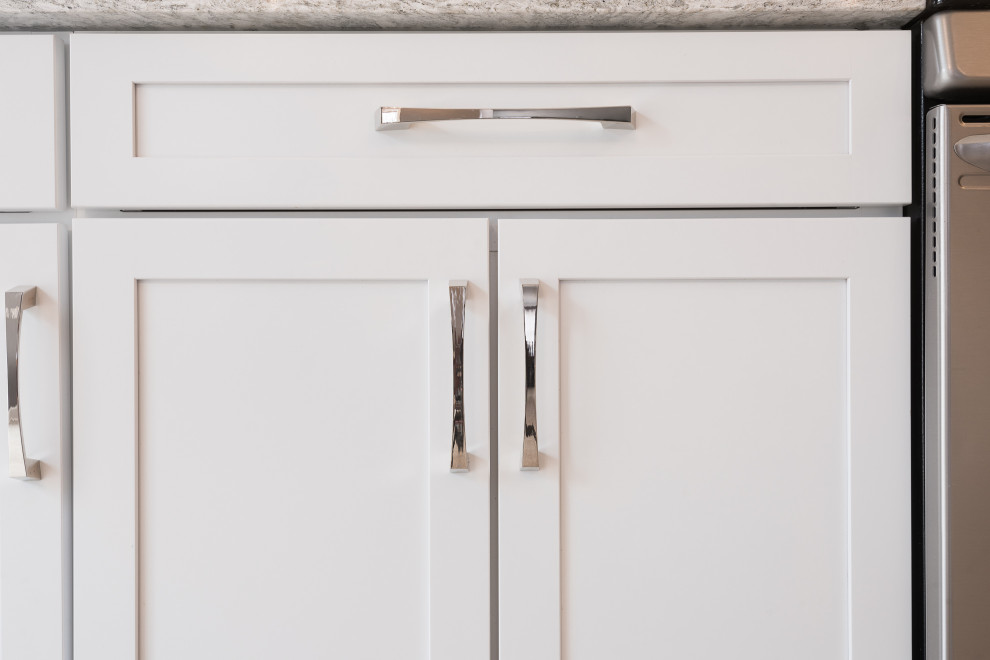 Inspiration for a mid-sized transitional galley vinyl floor and beige floor open concept kitchen remodel with an undermount sink, recessed-panel cabinets, white cabinets, quartz countertops, white backsplash, stone tile backsplash, stainless steel appliances, a peninsula and multicolored countertops