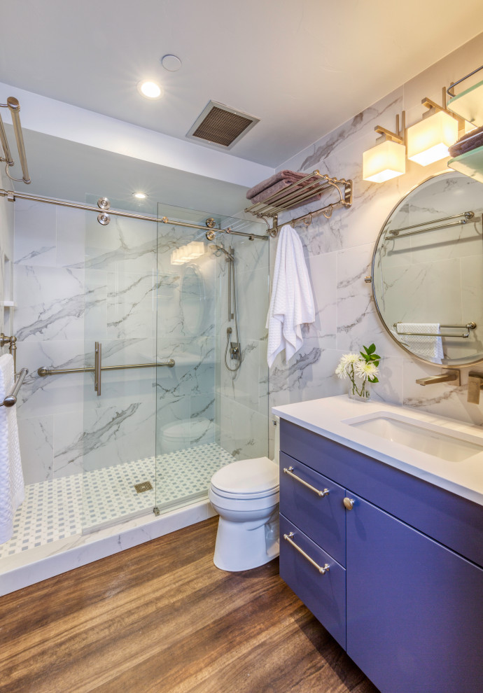 Пример оригинального дизайна: ванная комната среднего размера в стиле фьюжн с плоскими фасадами, синими фасадами, серой плиткой, керамогранитной плиткой, душевой кабиной, врезной раковиной, столешницей из искусственного кварца, душем с раздвижными дверями, белой столешницей, тумбой под одну раковину и подвесной тумбой
