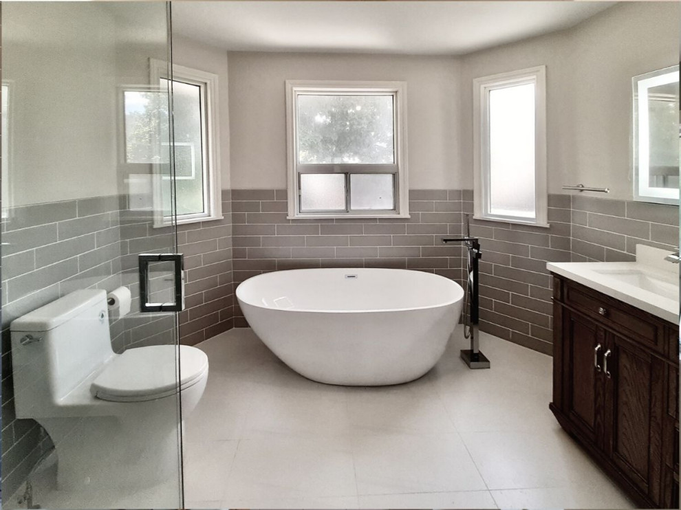 Свежая идея для дизайна: большая главная ванная комната в современном стиле с темными деревянными фасадами, отдельно стоящей ванной, душем без бортиков, бежевой плиткой, душем с распашными дверями, белой столешницей и напольной тумбой - отличное фото интерьера