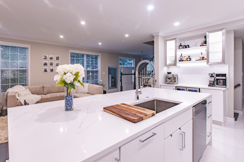 ワシントンD.C.にあるコンテンポラリースタイルのおしゃれなキッチン (ドロップインシンク、ベージュキッチンパネル、シルバーの調理設備、白いキッチンカウンター) の写真
