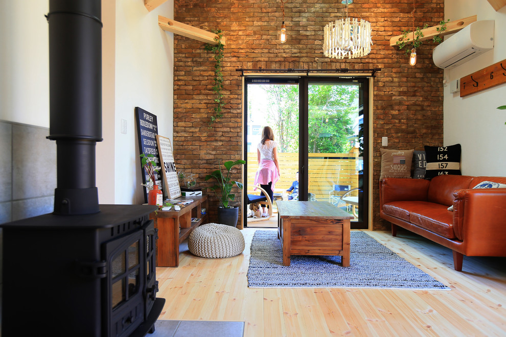 This is an example of an industrial open concept living room in Other with white walls, light hardwood floors, a wood stove and no tv.