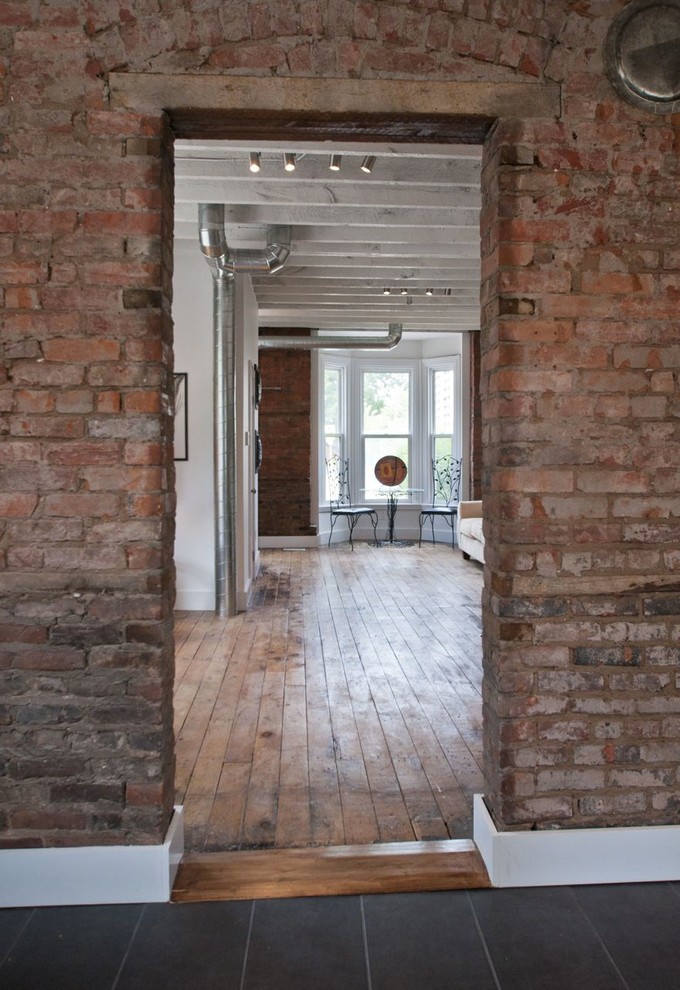Photo of an industrial family room in Toronto with white walls.