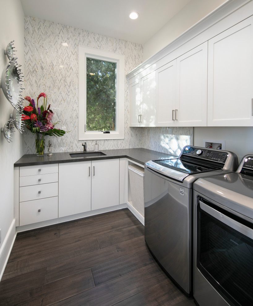 Medium sized contemporary galley separated utility room in San Luis Obispo with a submerged sink, recessed-panel cabinets, white cabinets, white walls, dark hardwood flooring, a side by side washer and dryer, brown floors, black worktops and wallpapered walls.