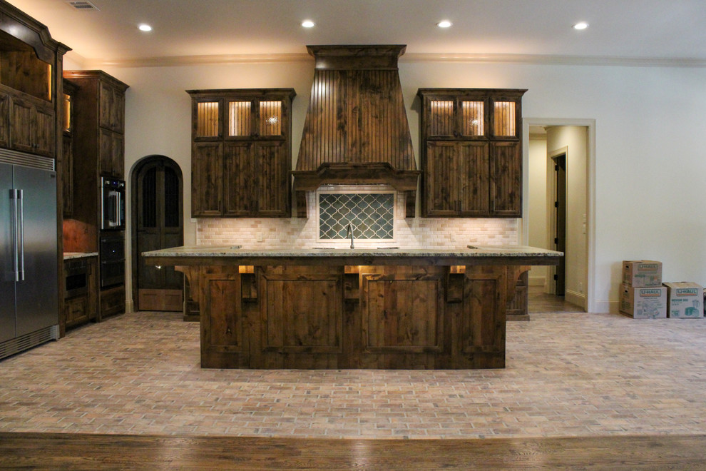 This is an example of a large traditional u-shaped open plan kitchen in Dallas with a drop-in sink, shaker cabinets, medium wood cabinets, granite benchtops, multi-coloured splashback, stone tile splashback, stainless steel appliances, porcelain floors, with island, multi-coloured floor and green benchtop.