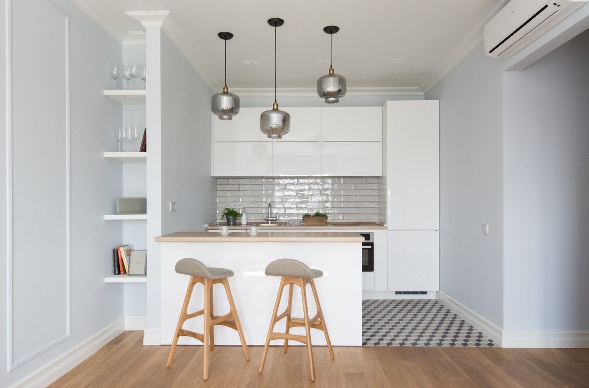 Scandinavian single-wall open plan kitchen in Moscow with a drop-in sink, flat-panel cabinets, white cabinets, white splashback, stainless steel appliances, a peninsula and multi-coloured floor.