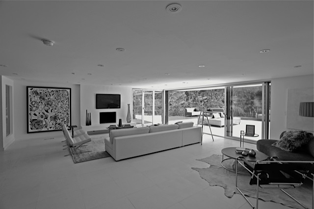 Design ideas for a large modern open concept living room in Los Angeles with white walls and a wall-mounted tv.