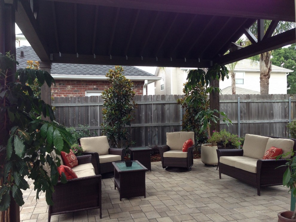 Inspiration for a large traditional backyard patio in New Orleans with natural stone pavers and a pergola.