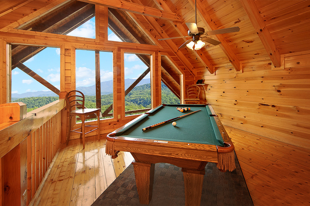 This is an example of a mid-sized country loft-style family room in Other with a game room, brown walls, medium hardwood floors, no fireplace and no tv.