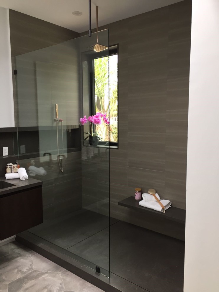 Inspiration for a large modern master bathroom in Los Angeles with flat-panel cabinets, dark wood cabinets, an alcove shower, beige tile, ceramic tile, beige walls, laminate floors, an undermount sink, solid surface benchtops, grey floor and an open shower.