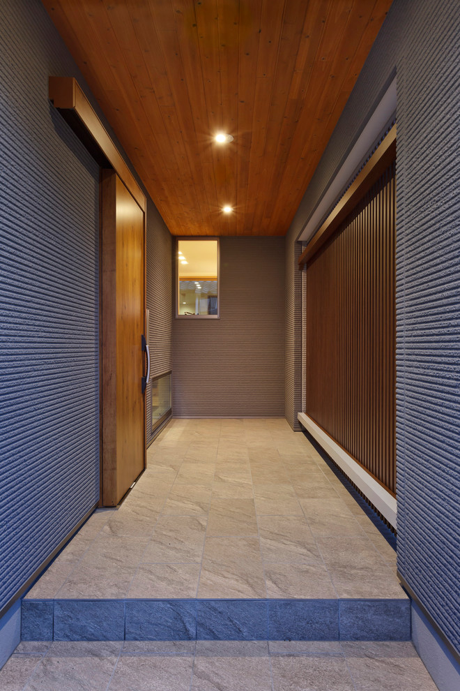 Photo of an asian entryway in Other with grey walls, a medium wood front door and grey floor.