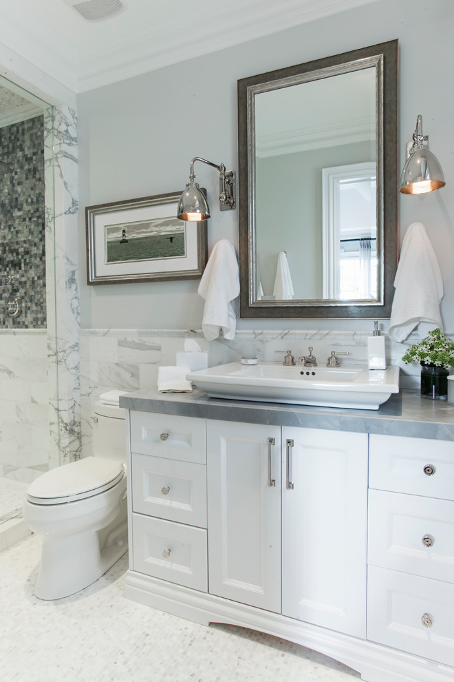 Design ideas for a mid-sized traditional 3/4 bathroom in Toronto with white cabinets, white tile, a vessel sink, recessed-panel cabinets, stone tile, mosaic tile floors, an alcove shower, a two-piece toilet, grey walls, glass benchtops, white floor and grey benchtops.