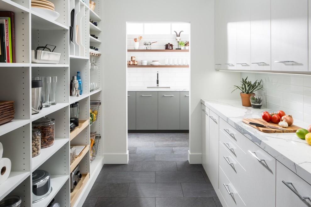 Inspiration for a mid-sized contemporary galley kitchen pantry in Chicago with flat-panel cabinets, grey floor, no island, white cabinets, marble benchtops, white splashback, subway tile splashback and slate floors.