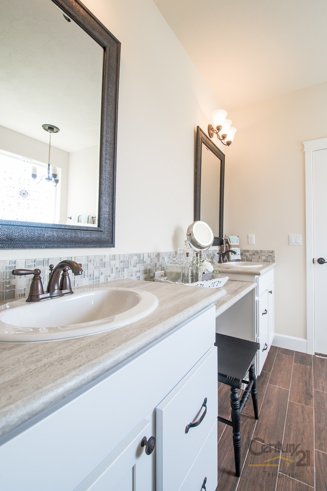 Design ideas for a large country master bathroom in Seattle with a drop-in sink, shaker cabinets, white cabinets, granite benchtops, a drop-in tub, an alcove shower, a two-piece toilet, gray tile, glass tile, beige walls and linoleum floors.
