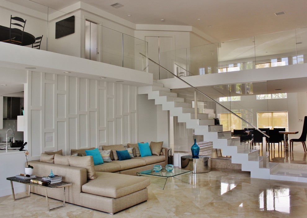 This is an example of a large modern living room in Miami with white walls, marble floors and no fireplace.