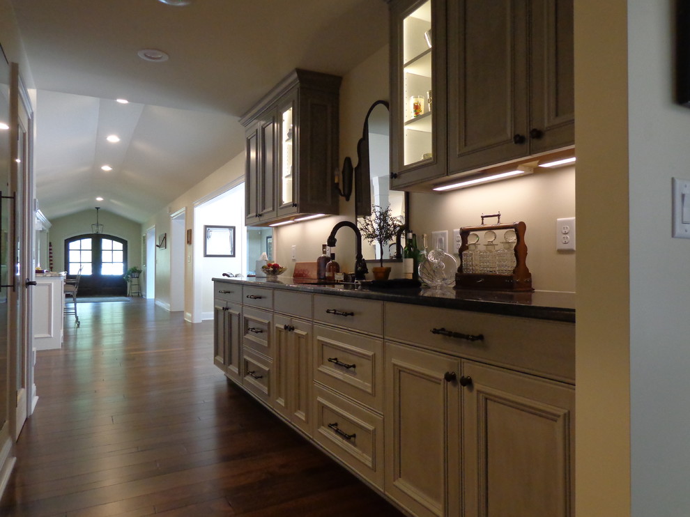 Inspiration for a large transitional u-shaped dark wood floor open concept kitchen remodel in Raleigh with a farmhouse sink, recessed-panel cabinets, white cabinets, granite countertops, white backsplash, subway tile backsplash, stainless steel appliances and an island
