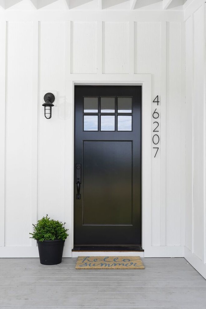 Modern Farmhouse - Example of a farmhouse front door design in Chicago with a black front door