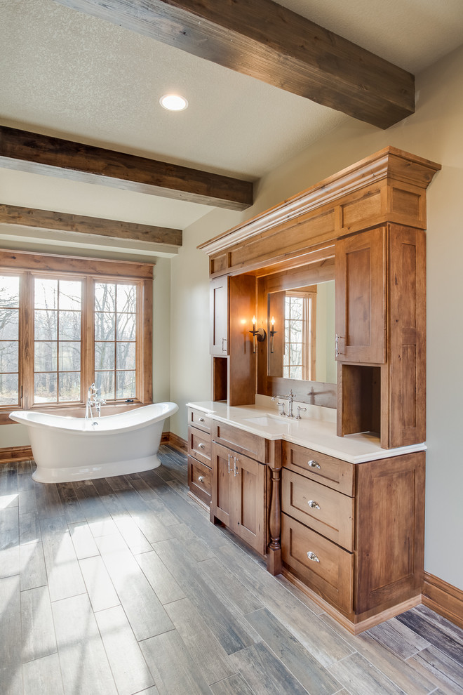 Example of a large mountain style master multicolored tile and ceramic tile ceramic tile freestanding bathtub design with an undermount sink, recessed-panel cabinets, medium tone wood cabinets, quartzite countertops, a two-piece toilet and beige walls