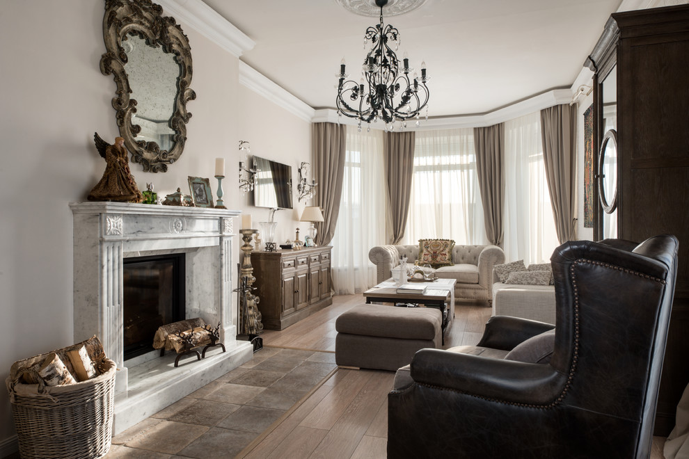 Traditional enclosed living room in Moscow with a standard fireplace, a stone fireplace surround, a wall-mounted tv and brown floor.