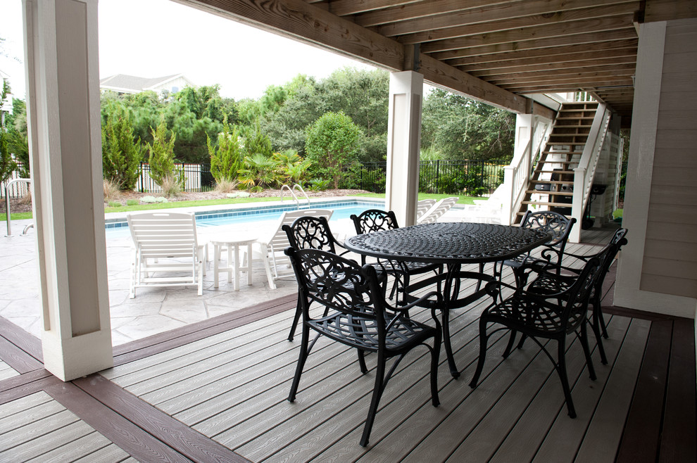 Example of a mid-sized beach style backyard deck design with a roof extension