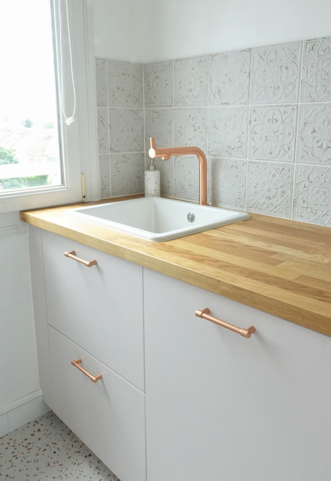 Mid-sized modern galley eat-in kitchen in Other with an undermount sink, beaded inset cabinets, pink cabinets, wood benchtops, white splashback, ceramic splashback, white appliances, terrazzo floors, a peninsula, beige floor and beige benchtop.