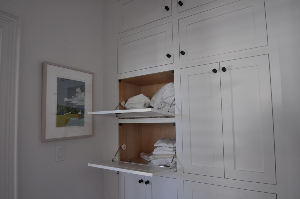 Foto de armario y vestidor clásico renovado pequeño con a medida, armarios con paneles empotrados, puertas de armario blancas, suelo de madera oscura y suelo marrón