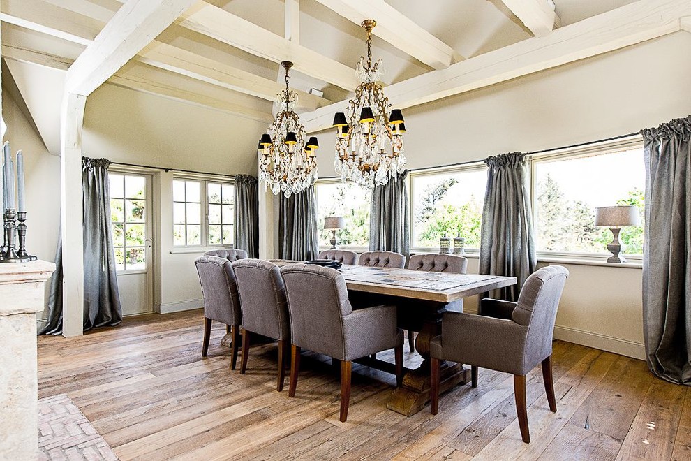 This is an example of a large country dining room in Hamburg with beige walls and medium hardwood floors.