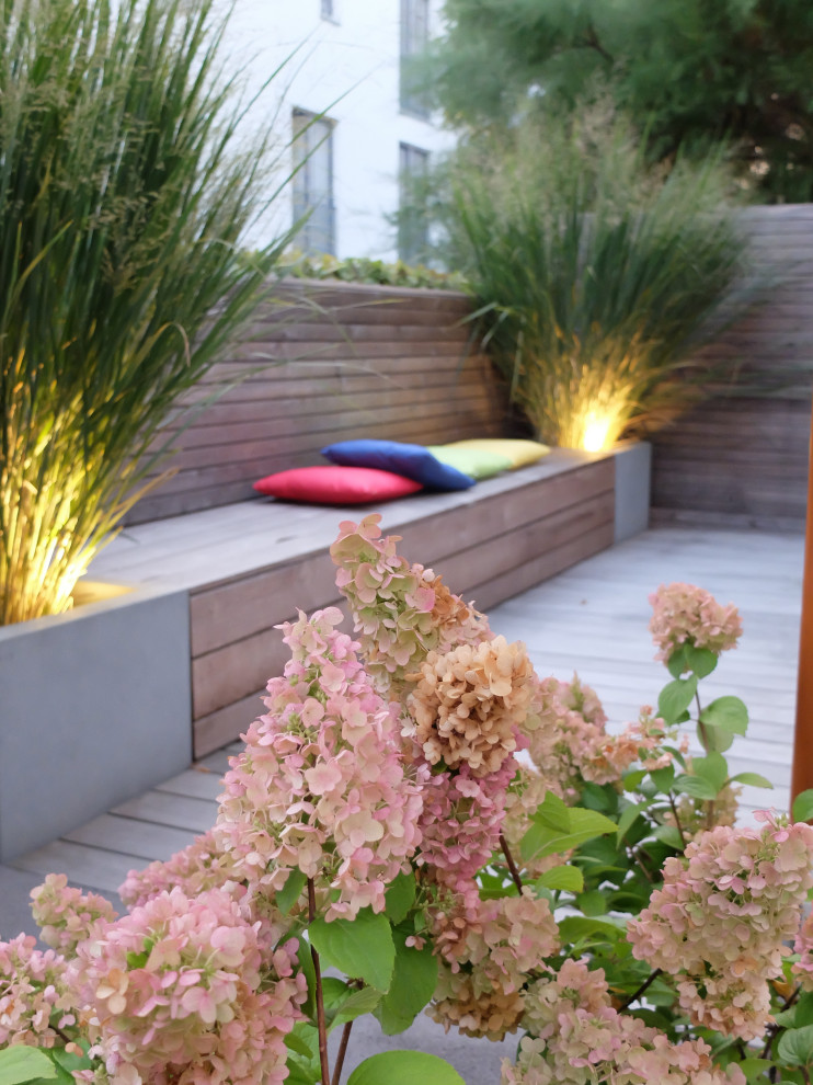 Пример оригинального дизайна: маленький летний регулярный сад на боковом дворе в стиле модернизм с перегородкой для приватности, полуденной тенью, настилом и с деревянным забором для на участке и в саду