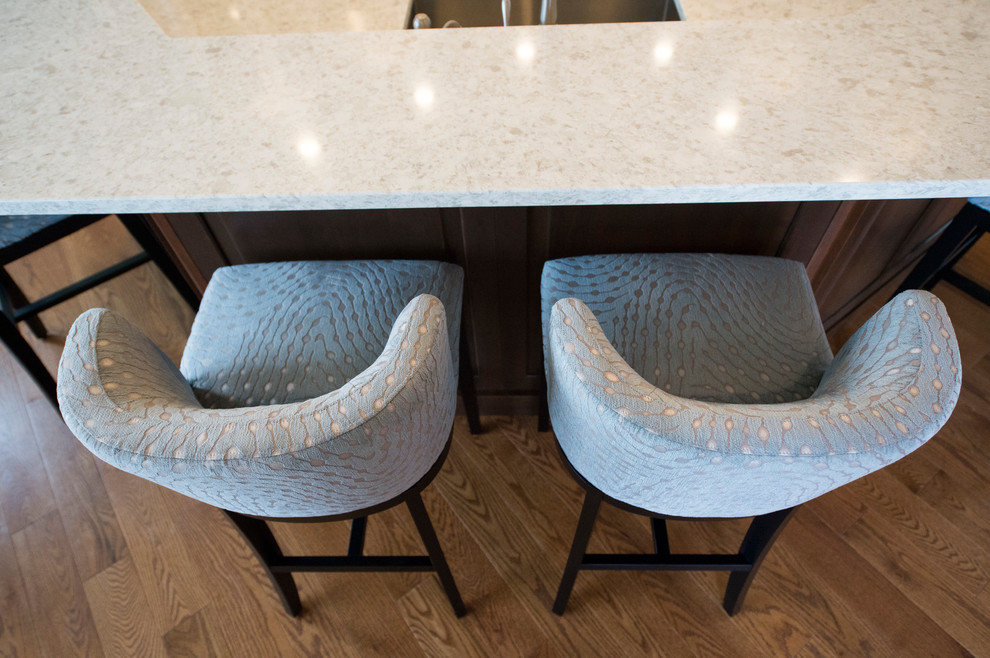 Eat-in kitchen - transitional l-shaped medium tone wood floor eat-in kitchen idea in Boston with white cabinets, granite countertops, gray backsplash, stainless steel appliances and an island