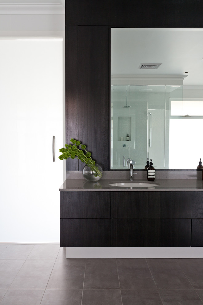 This is an example of an expansive contemporary master bathroom in Perth with an undermount sink, flat-panel cabinets, brown cabinets, engineered quartz benchtops, a freestanding tub, a double shower, gray tile, ceramic tile and white walls.