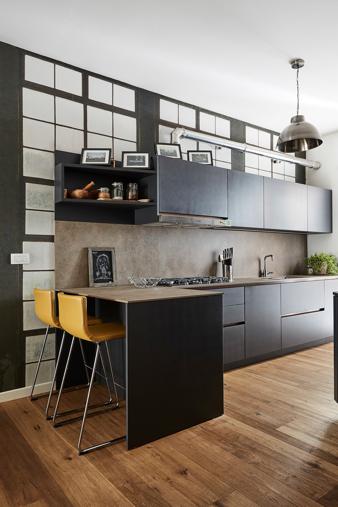 Photo of a mid-sized contemporary l-shaped open plan kitchen in Milan with a double-bowl sink, flat-panel cabinets, black cabinets, brown splashback, panelled appliances, medium hardwood floors, a peninsula and brown floor.