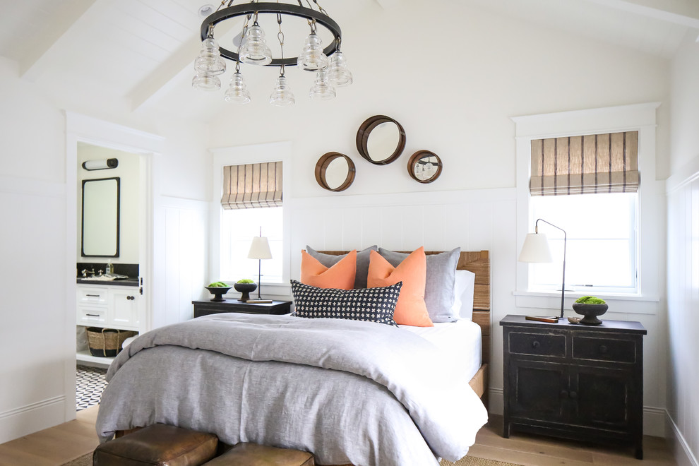 This is an example of a beach style bedroom in Los Angeles with beige walls, medium hardwood floors and brown floor.