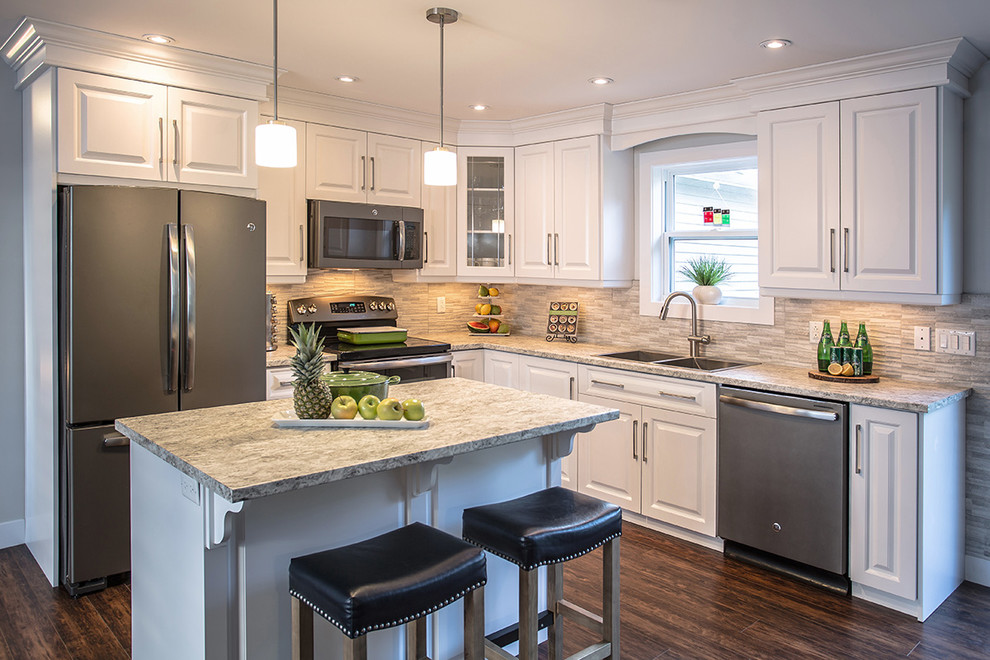 Example of a mid-sized l-shaped eat-in kitchen design with a double-bowl sink, raised-panel cabinets, white cabinets, gray backsplash, stainless steel appliances and an island
