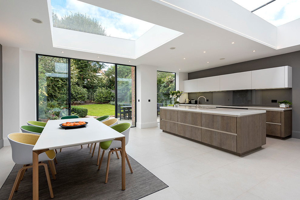 This is an example of a contemporary galley eat-in kitchen in Other with flat-panel cabinets, dark wood cabinets, grey splashback, with island and beige floor.