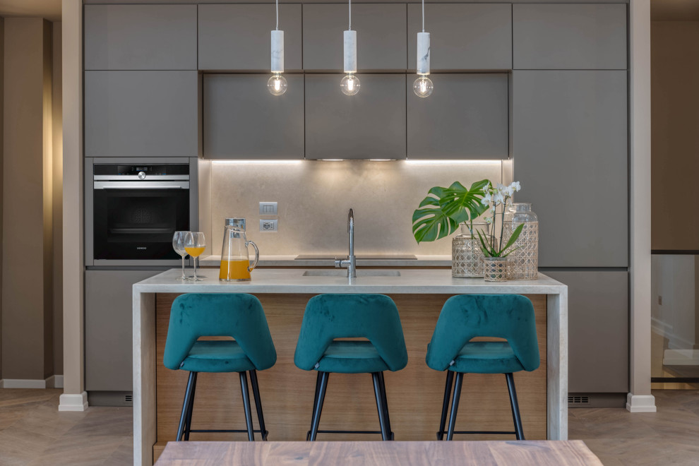 Large contemporary single-wall eat-in kitchen in Florence with flat-panel cabinets, grey cabinets, limestone benchtops, limestone splashback, stainless steel appliances, light hardwood floors, with island, a single-bowl sink, grey splashback and grey benchtop.