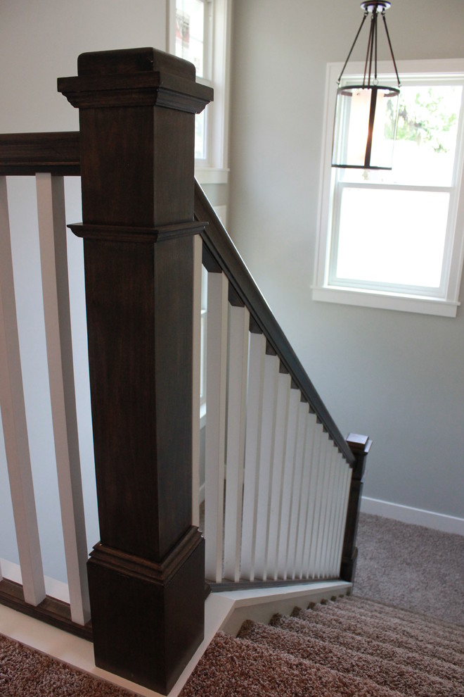 Photo of a large transitional carpeted u-shaped staircase in Minneapolis with concrete risers and wood railing.