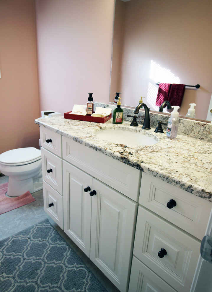 Mid-sized traditional bathroom in Wilmington with raised-panel cabinets, white cabinets and granite benchtops.