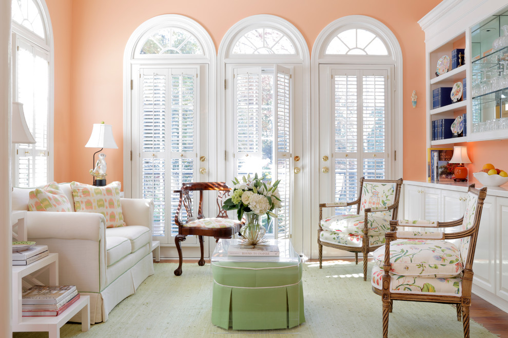 Design ideas for a traditional enclosed family room in Atlanta with pink walls, medium hardwood floors and no tv.