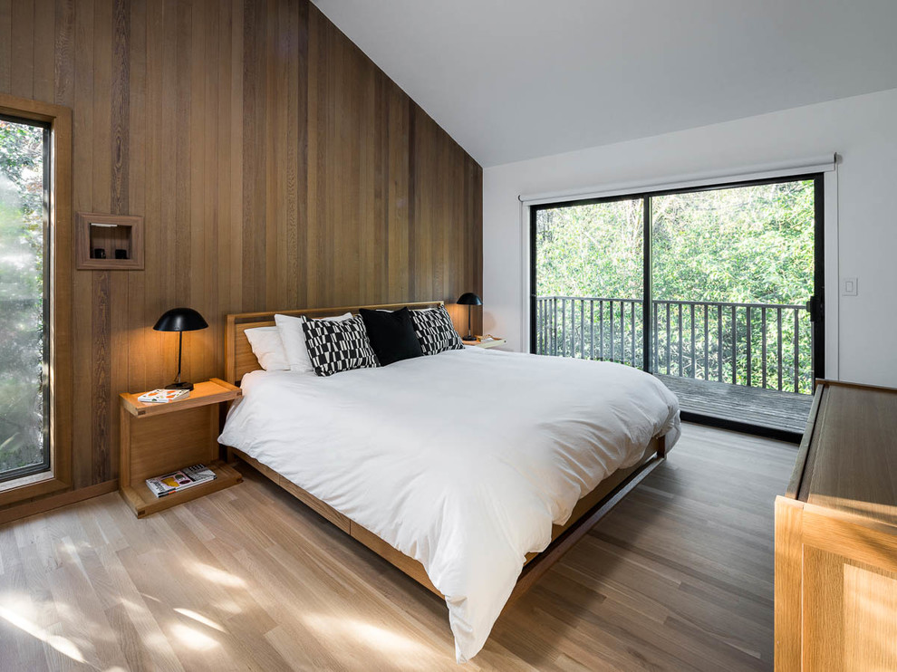 Modern bedroom in Portland with brown walls, medium hardwood floors and brown floor.